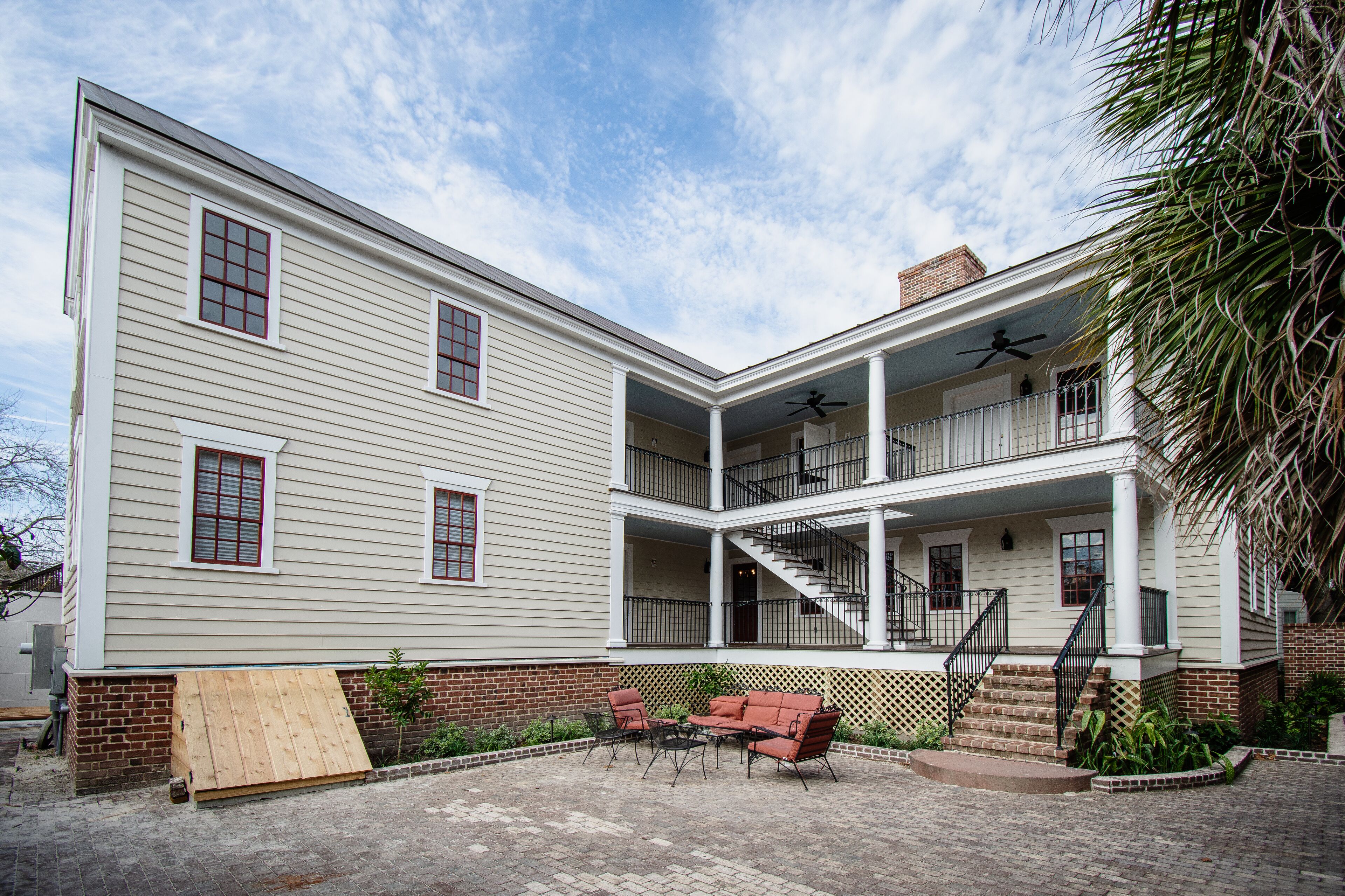 A two-story house with a covered patio, a staircase, and a balcony.
