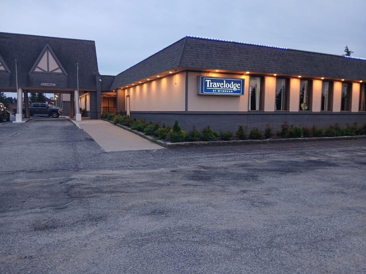A Travelodge by Wyndham hotel with a parking lot and a covered entrance.