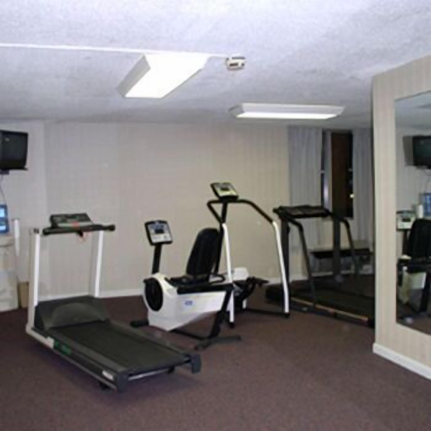 A fitness room with a treadmill, elliptical, and stationary bike.