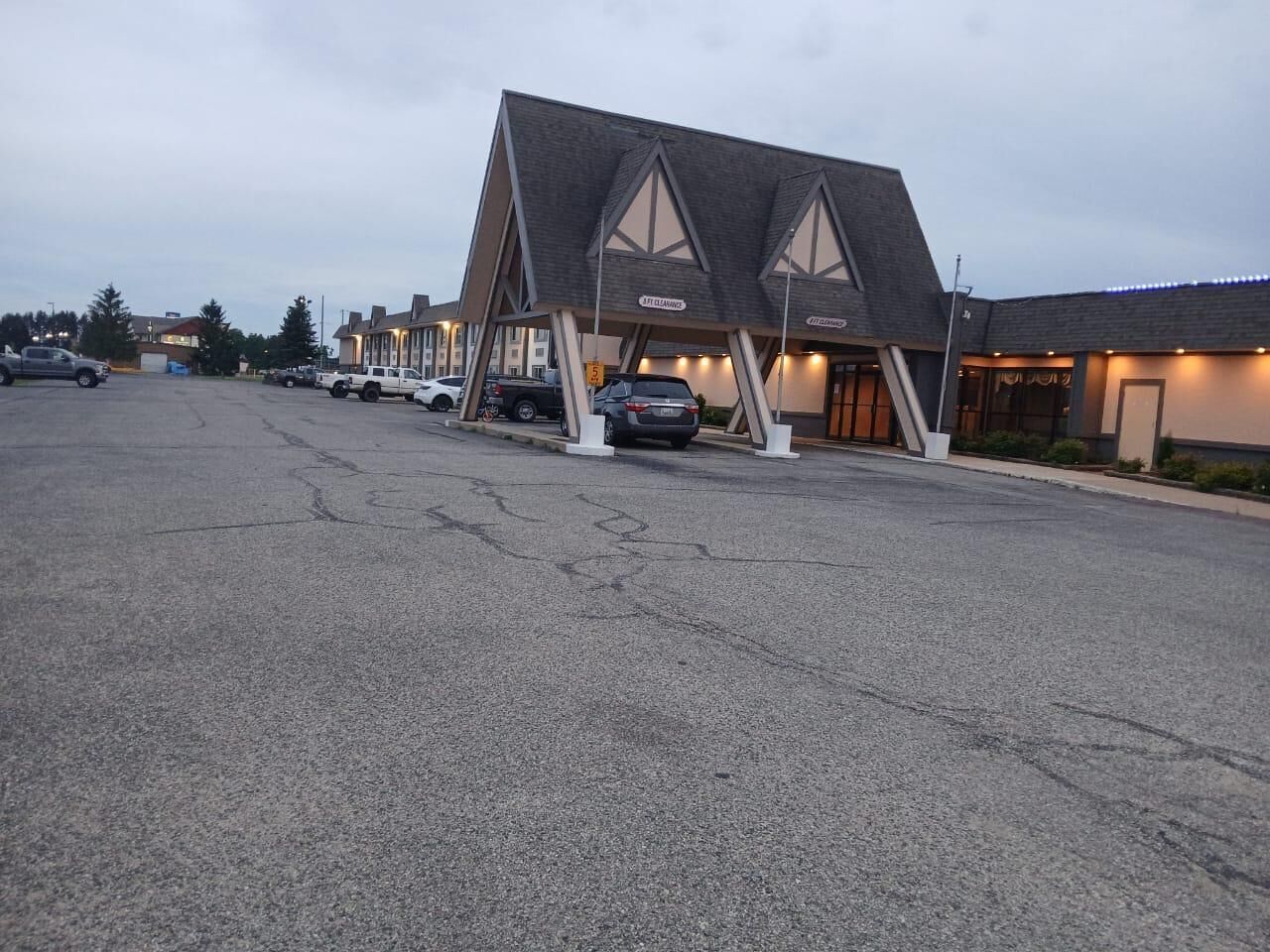 A parking lot with a building featuring a unique triangular roof design.