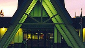 A building with a triangular roof structure and large windows.