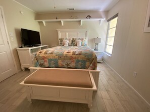 A bedroom with a bed, a television, a desk, and a window. - Sea Club II by Beachside Management (Siesta Key)