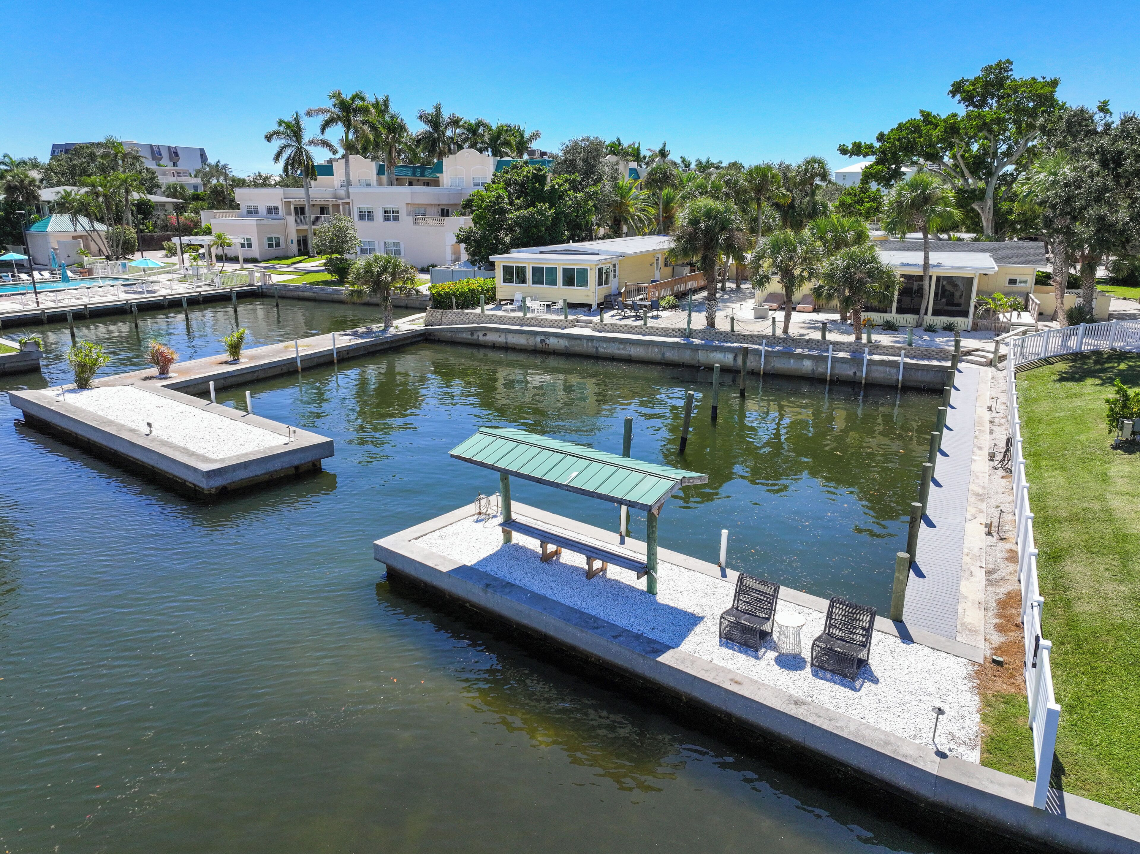 A marina with docks, a small boat, and a pool area with lounge chairs.