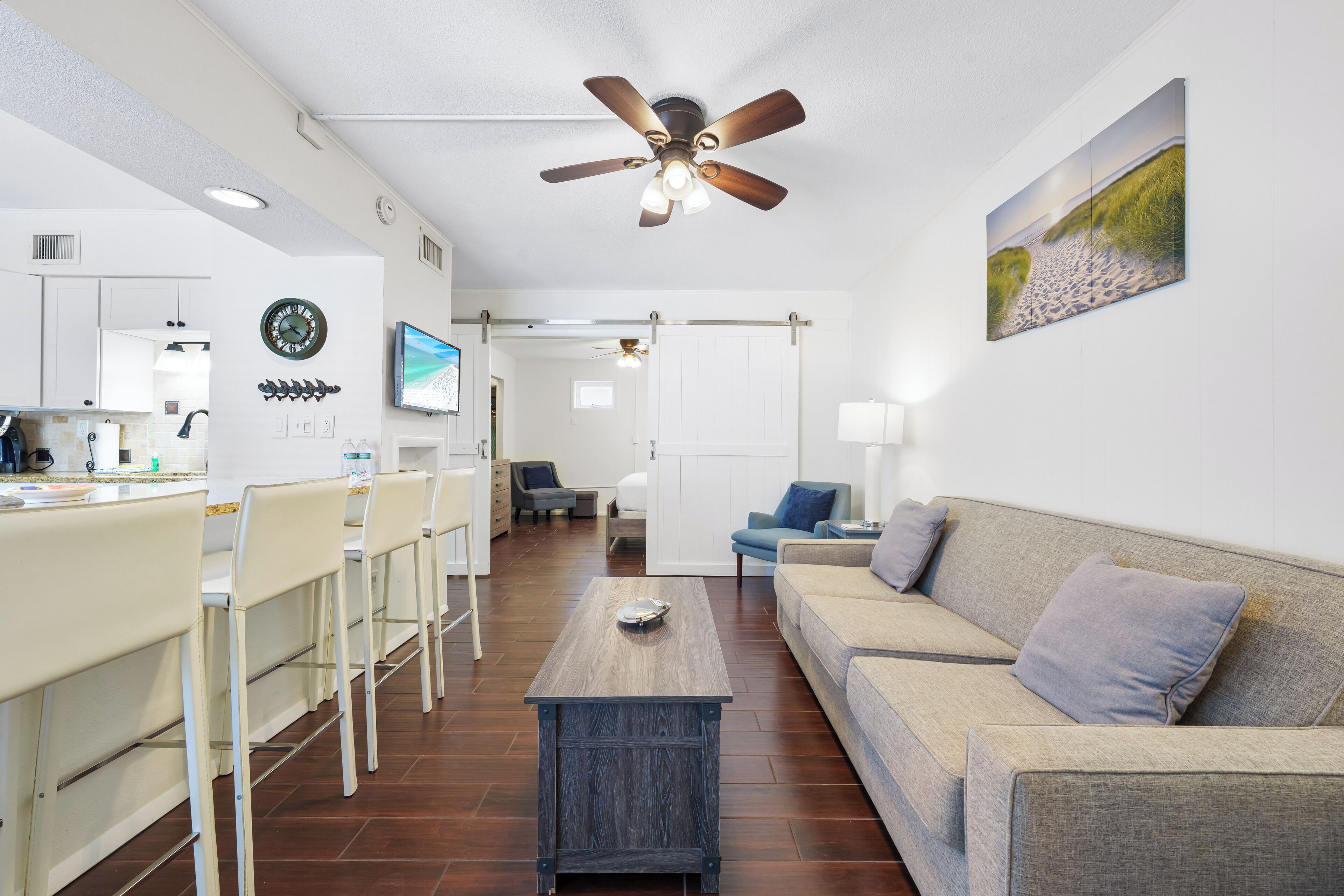 A modern living room with a wooden coffee table, a sofa, and a TV mounted on the wall.