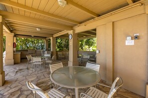 An outdoor patio area with stone flooring, metal tables, and chairs.