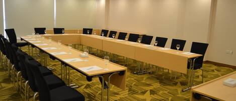 A conference room with a long table, chairs, and a projector.