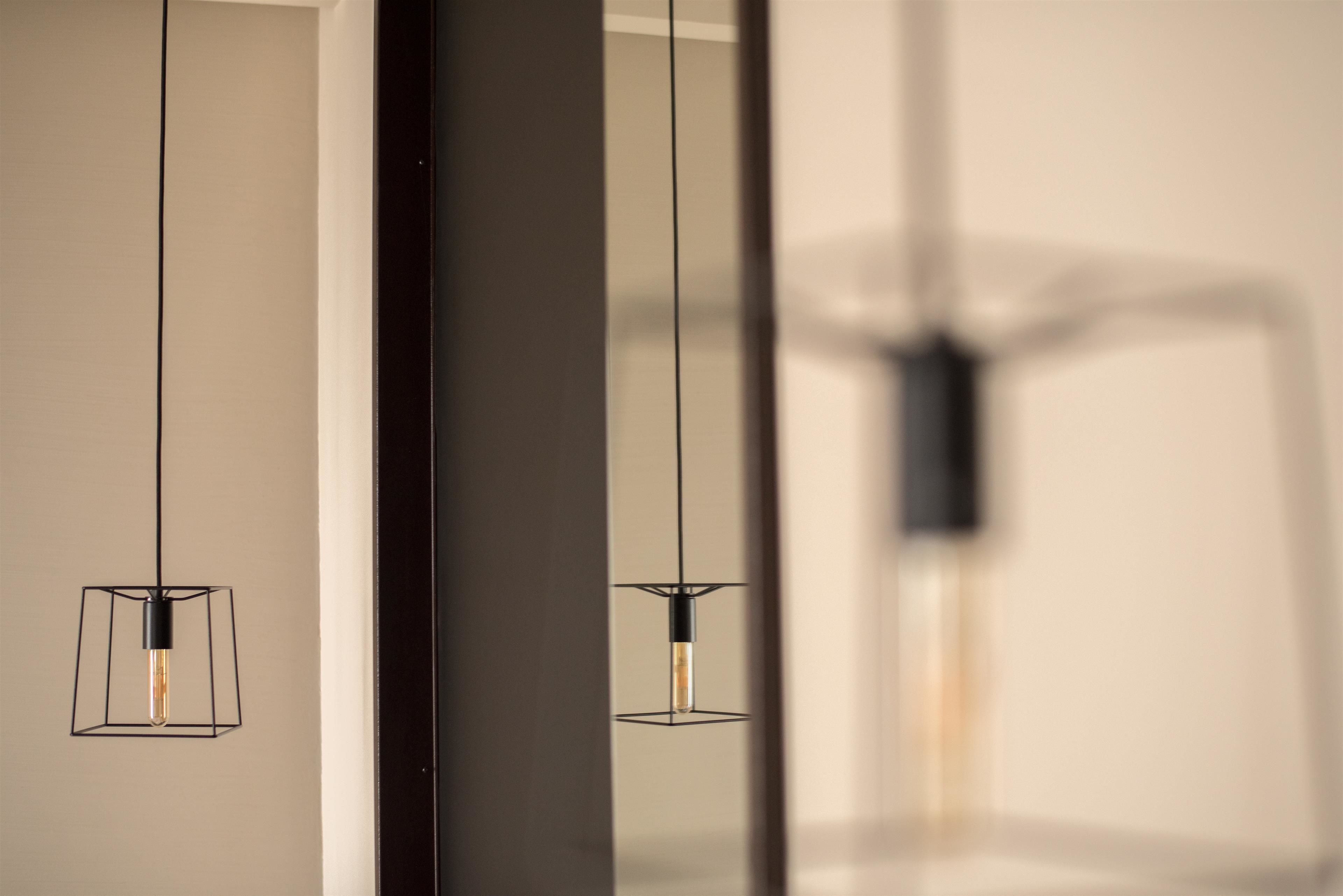 Ein modernes Interieur mit schlichten Pendelleuchten und einer reflektierenden Oberfläche.