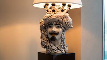 Eine dekorative Lampe mit einer kronenartigen Spitze und einem Gesicht am Sockel.