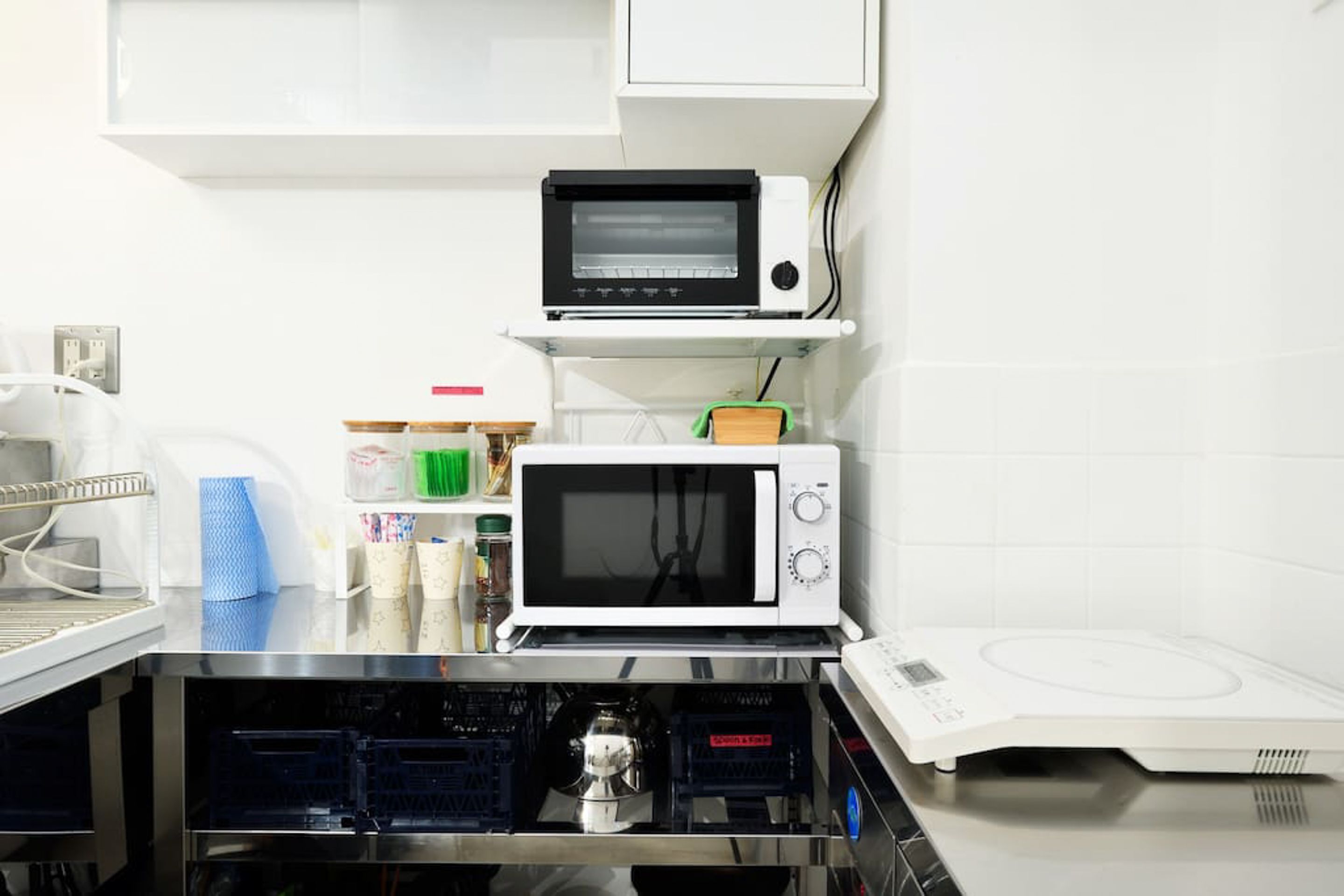 A kitchen with a microwave, toaster, and a water dispenser.