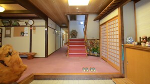 A traditional Japanese interior with a wooden staircase, tatami flooring, and sliding doors. - Oyado Nozawa (Takayama)