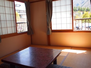 A traditional Japanese room with tatami flooring, a low wooden table, and shoji screens. - Oyado Nozawa (Takayama)