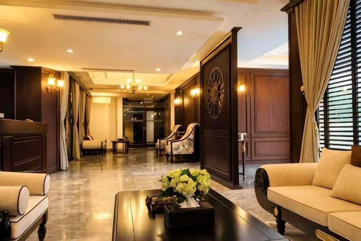 Amplia sala de estar con sofá, sillones, una mesa de centro y un adorno en la pared.