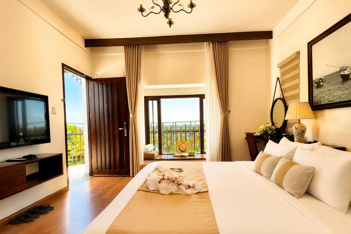 Habitación de hotel con cama, televisor, balcón y vista, además de una araña.