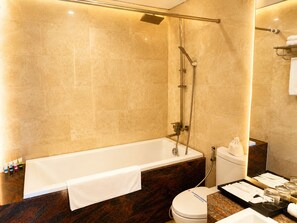 Un baño moderno con bañera, ducha e inodoro.