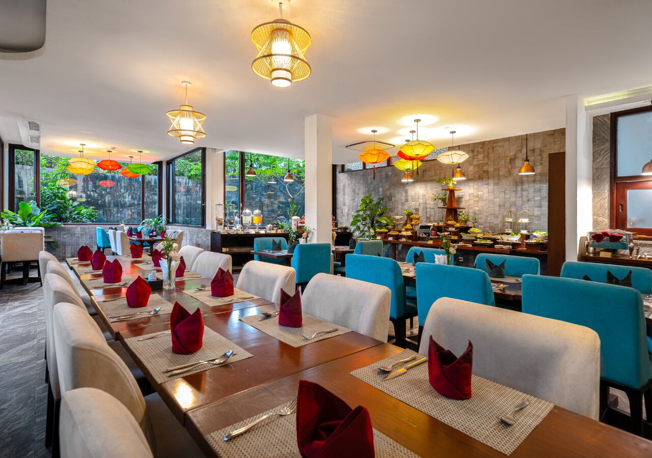 A restaurant with long communal tables, blue chairs, and red napkins.
