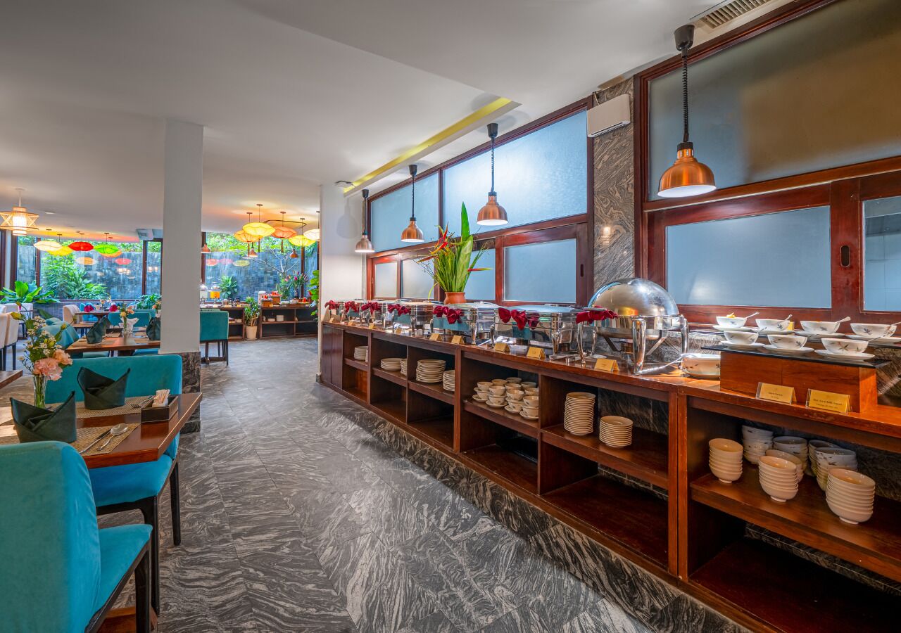 Un restaurant avec des chaises bleues, un buffet et un sol en marbre.