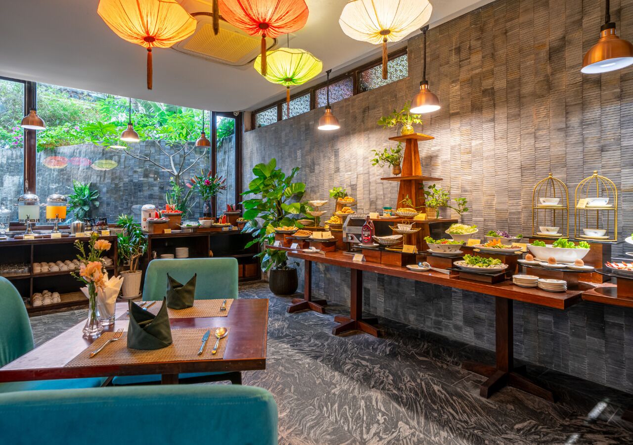 A restaurant with a long counter, multiple hanging lights, and a variety of dishes displayed.