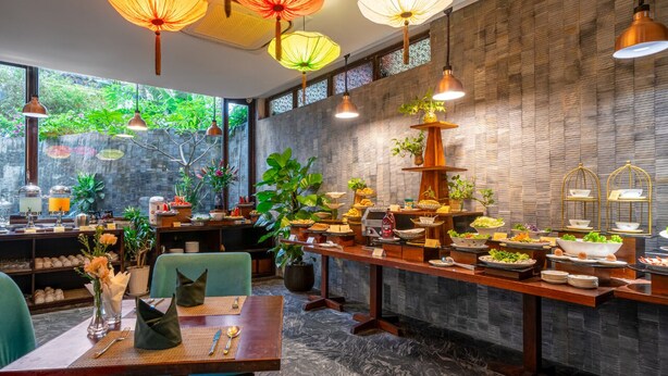 Un restaurante con una barra alargada, varias luces colgantes y una variedad de platos exhibidos.