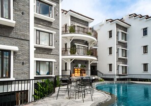 Una piscina al aire libre, sombrillas, tumbonas