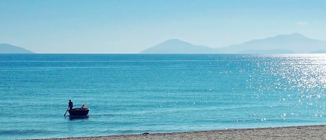 Una playa cerca, arena blanca, sillas reclinables de playa, sombrillas
