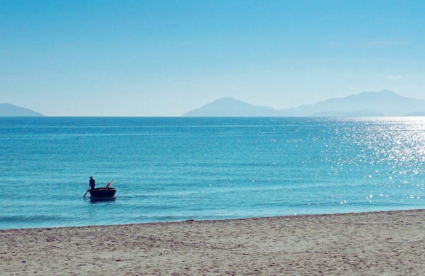 In Strandnähe, weißer Sandstrand, Liegestühle, Sonnenschirme