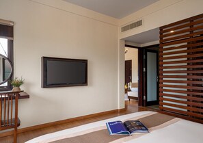 A hotel room with a flat-screen TV mounted on the wall, a bed with a striped rug, and a wooden partition. - Faifo Boutique Hotel & Spa (Da Nang)
