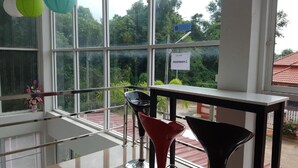 Un interior moderno con ventanas amplias, una mesa de vidrio y dos sillas.