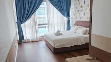 Habitación de hotel con cama, escritorio y ventilador de techo.