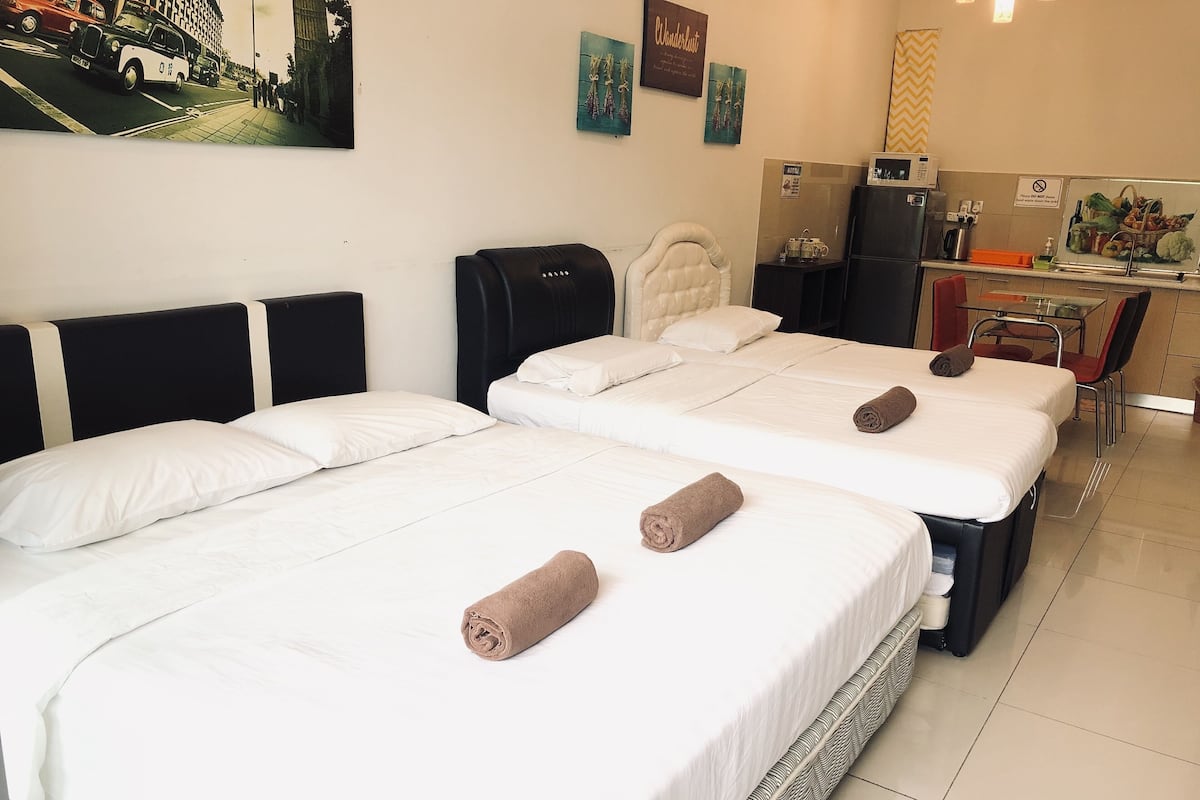 Una habitación de hotel con dos camas, una kitchenette y un comedor.