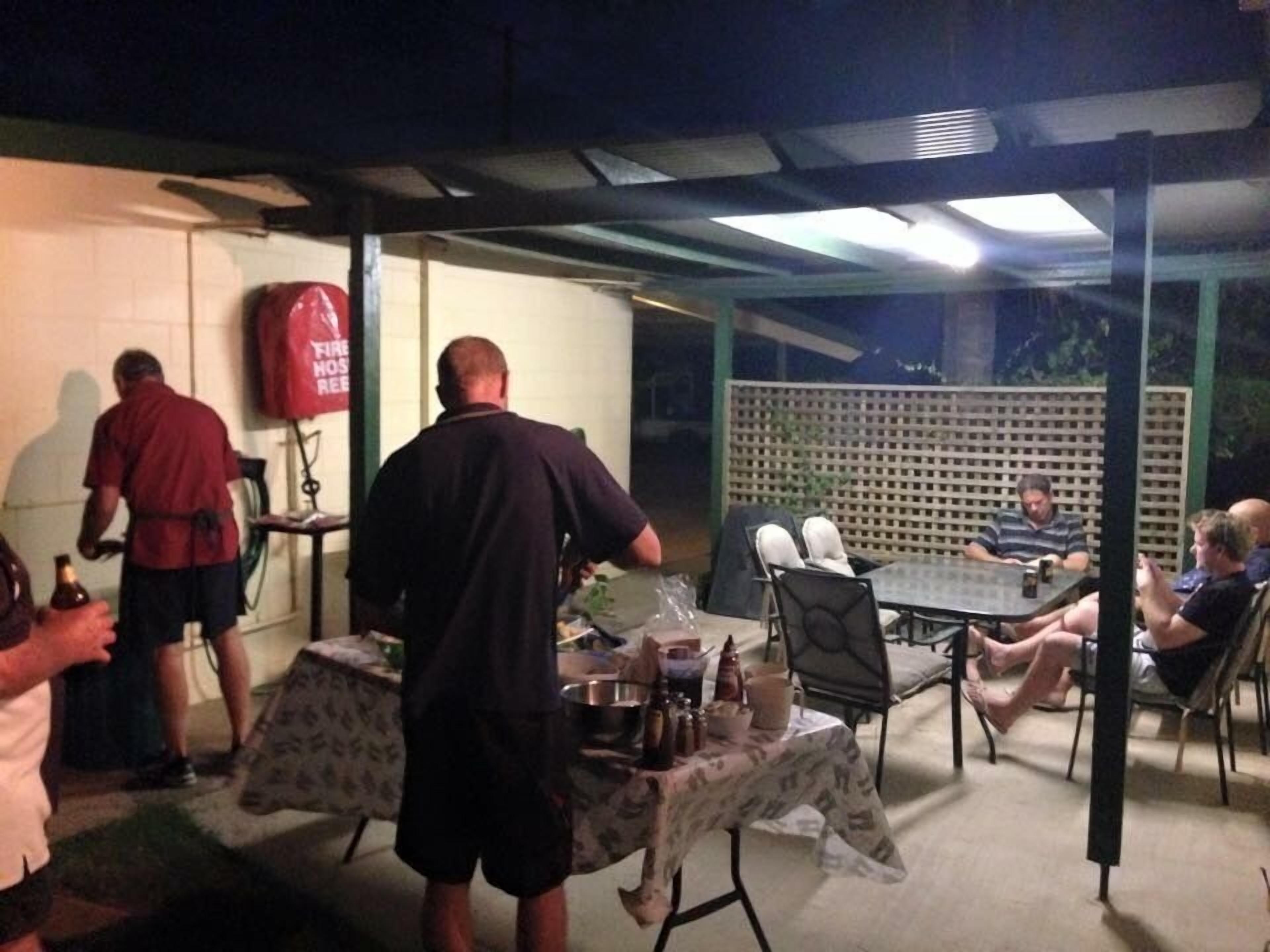 An outdoor patio area with a table set for dining, surrounded by chairs.