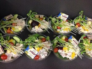 Multiple salad bowls with various vegetables and dressings.