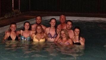 A group of people in a hot tub at night.