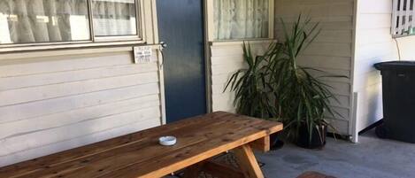 A wooden picnic table with benches in a covered outdoor area.