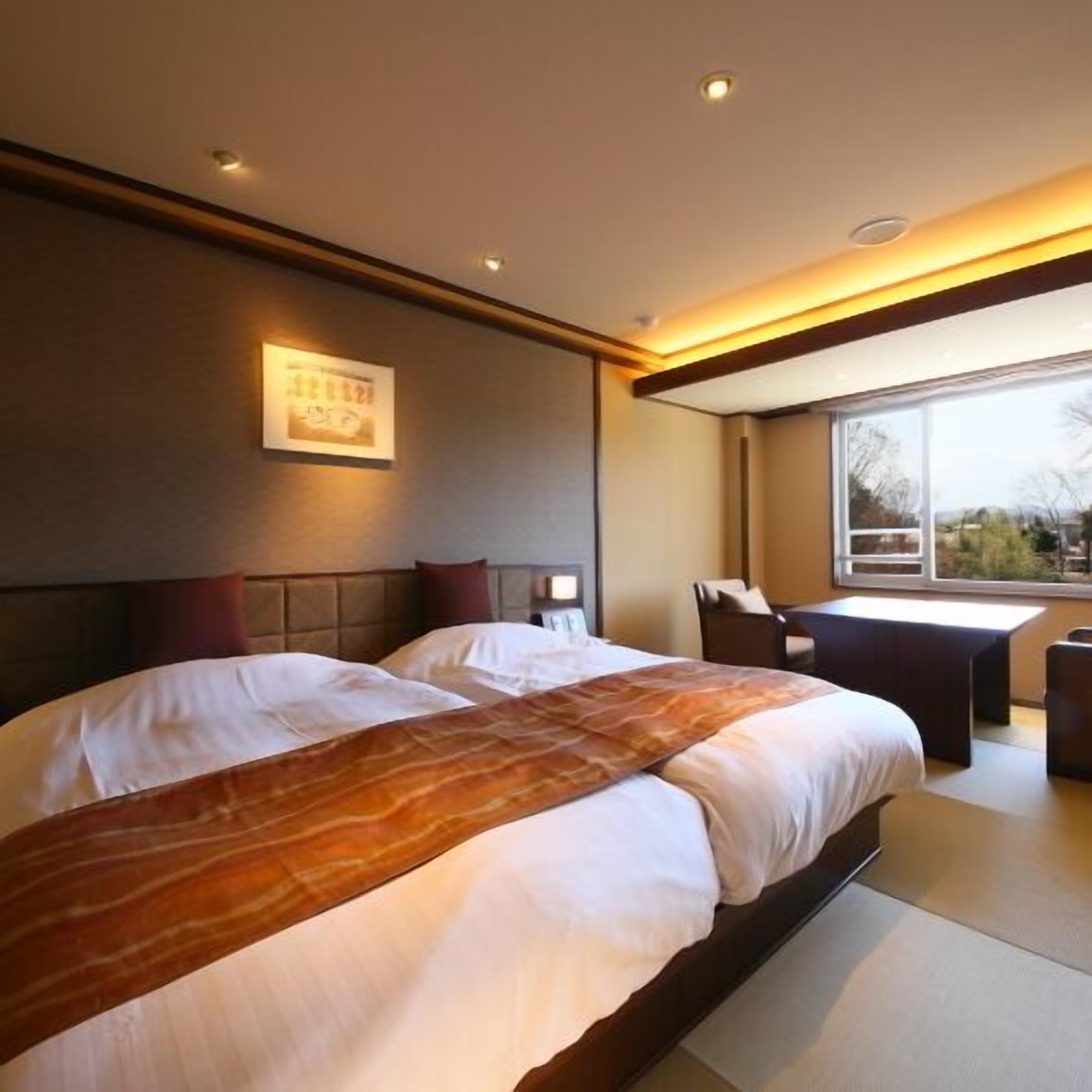 Une chambre d’hôtel avec un grand lit, un bureau et une fenêtre donnant sur un beau paysage.