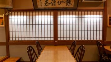 A traditional Japanese room with tatami flooring, a wooden table, and shoji screens.