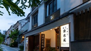 Un edificio tradicional japonés con un letrero que dice Shimizu Ryokan.