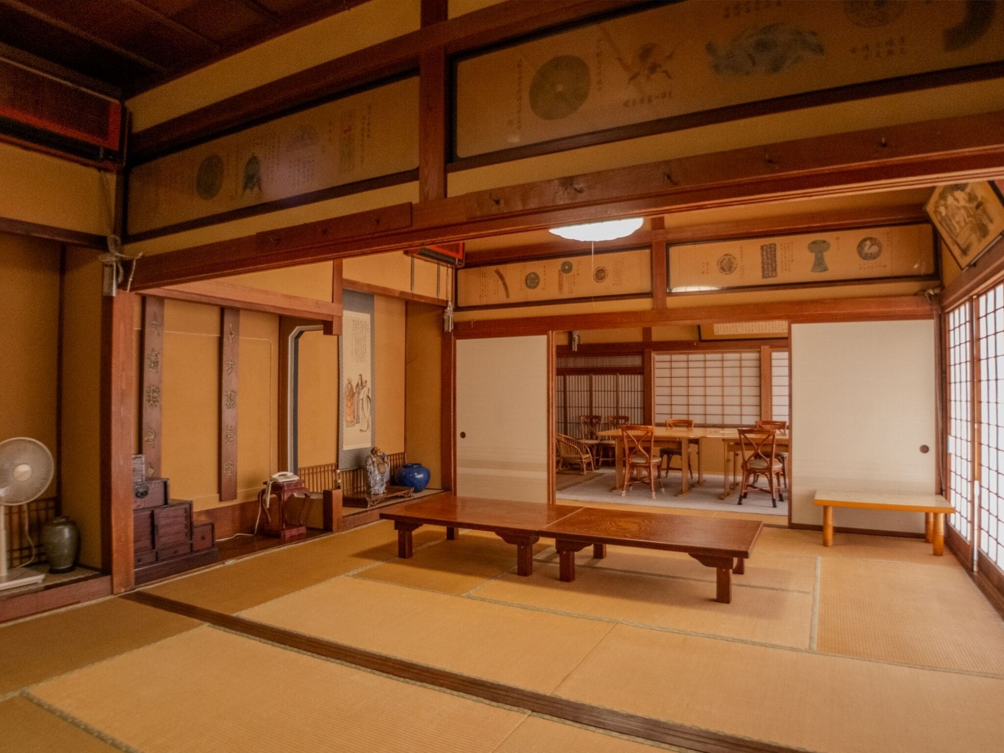 A traditional Japanese room with tatami flooring, wooden furniture, and sliding doors.