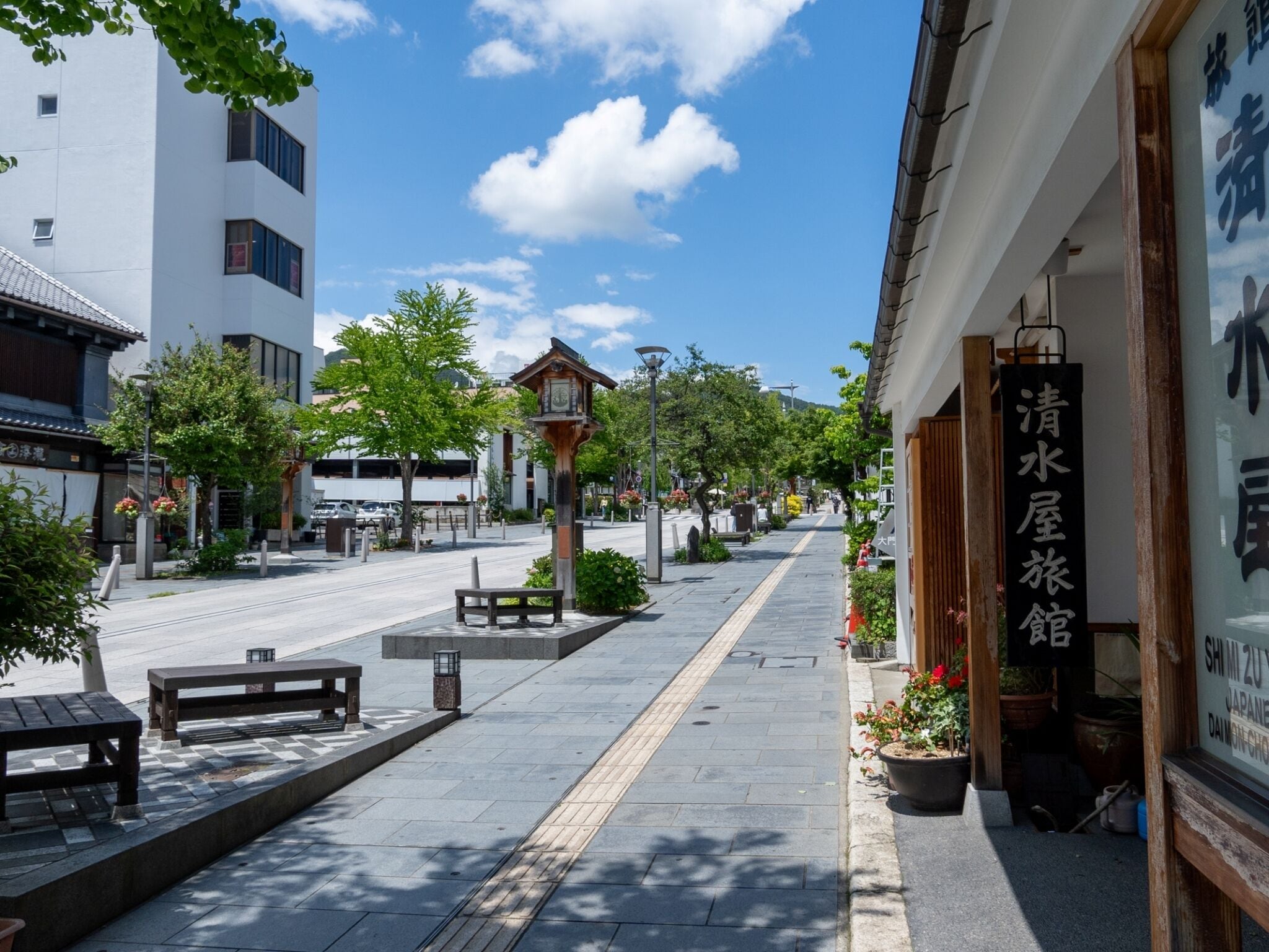 A street with a traditional Japanese building, a clear sky, and a sign for a water house.