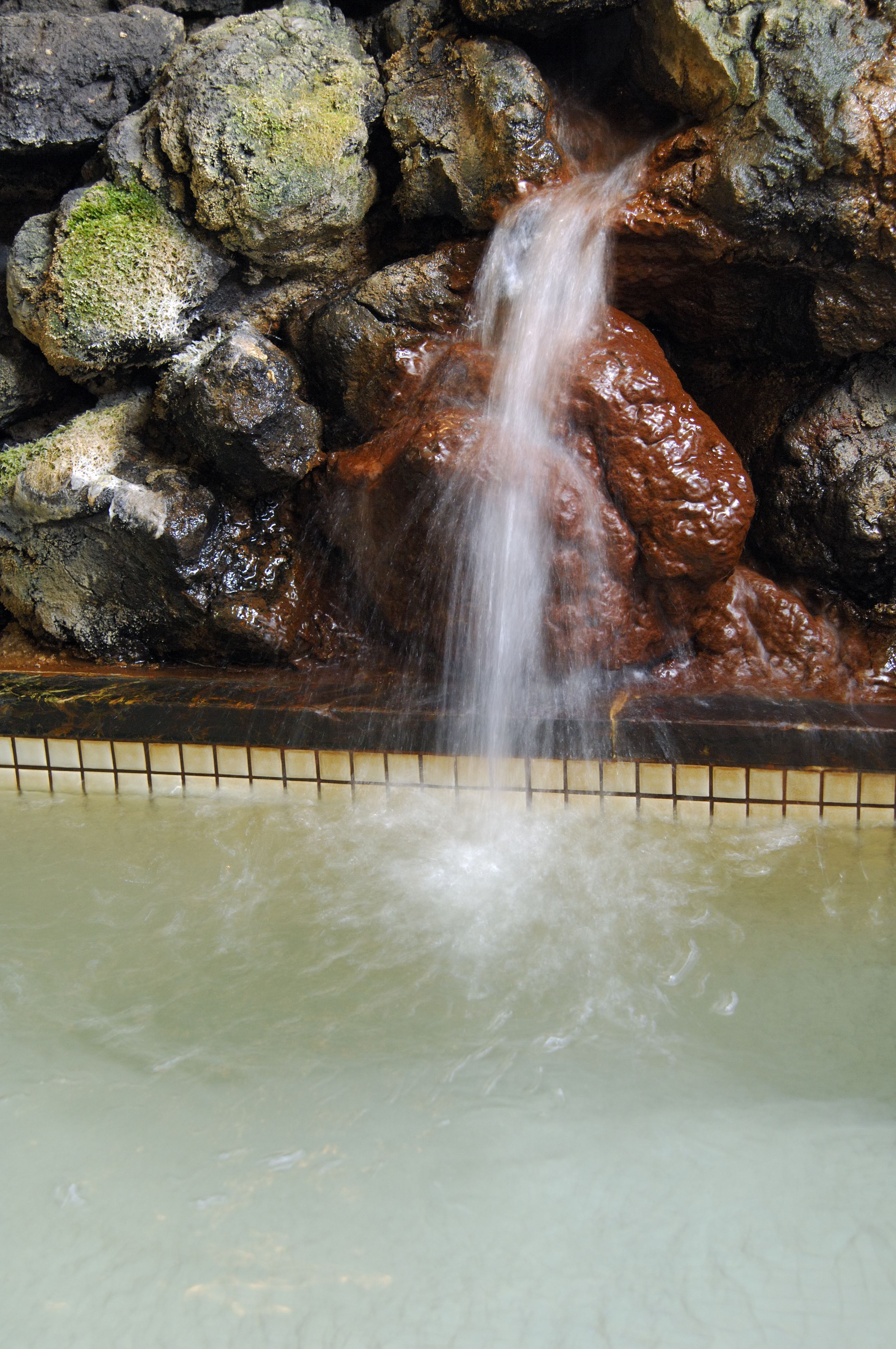 A waterfall feature with rocks and a tiled border.