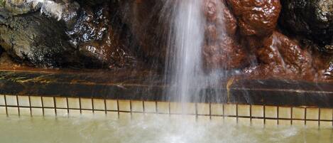 A waterfall feature with rocks and a tiled border.
