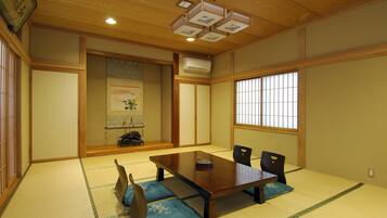 A traditional Japanese room with tatami flooring, a wooden table, and shoji screens.