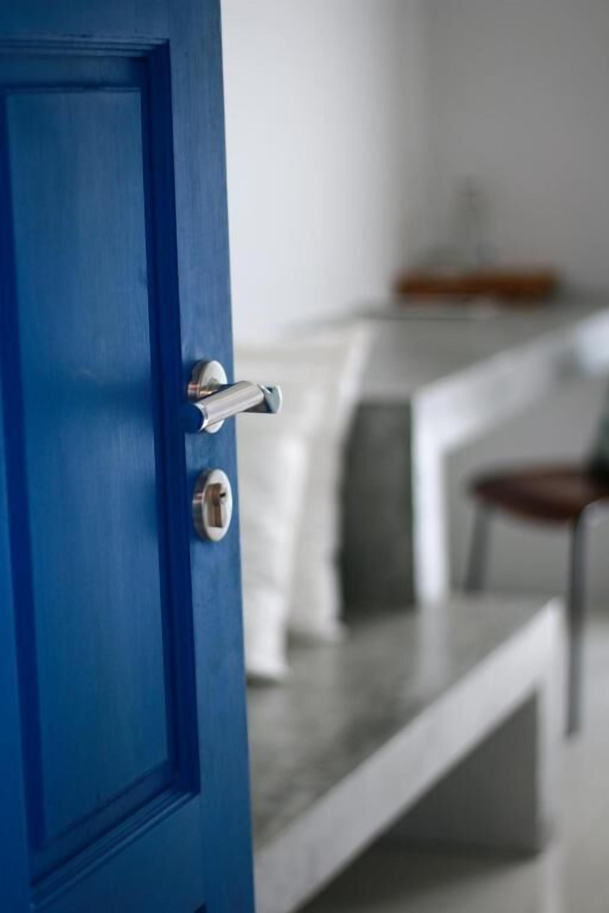 Una puerta azul con una cerradura y un picaporte plateado.