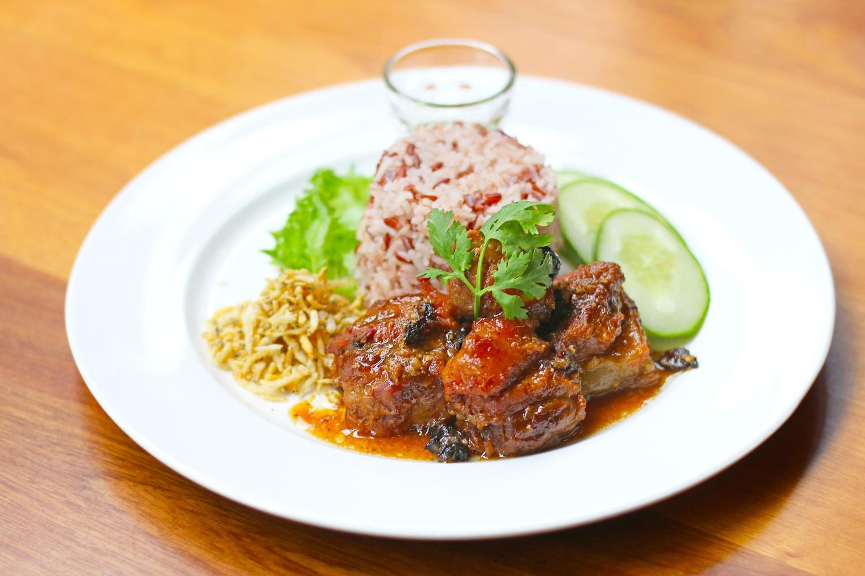 Ein Teller mit Reis, Fleisch und Gemüse.