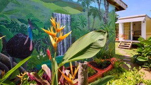 Un mural que representa una escena tropical con un ave, una cascada y abundante vegetación.
