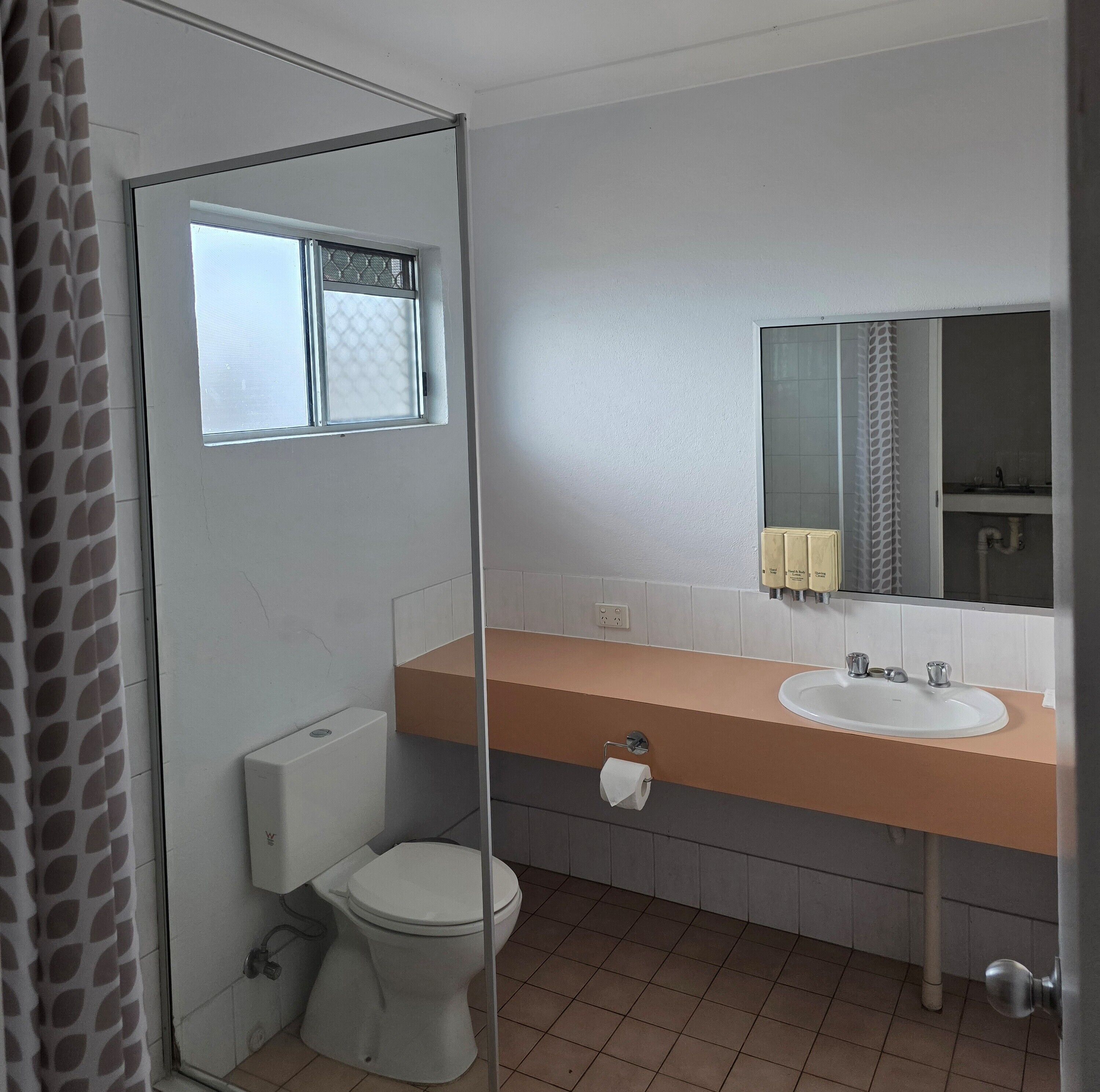 Un baño con inodoro, lavamanos y ducha.