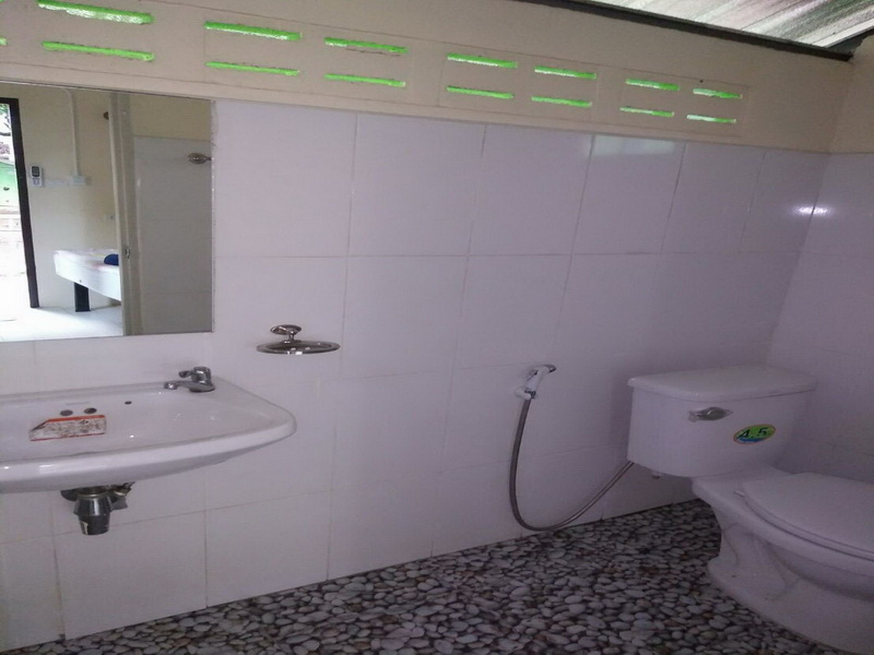 A bathroom with a white sink, toilet, and shower.