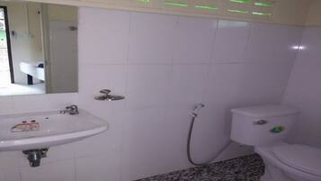 A bathroom with a white sink, toilet, and shower.