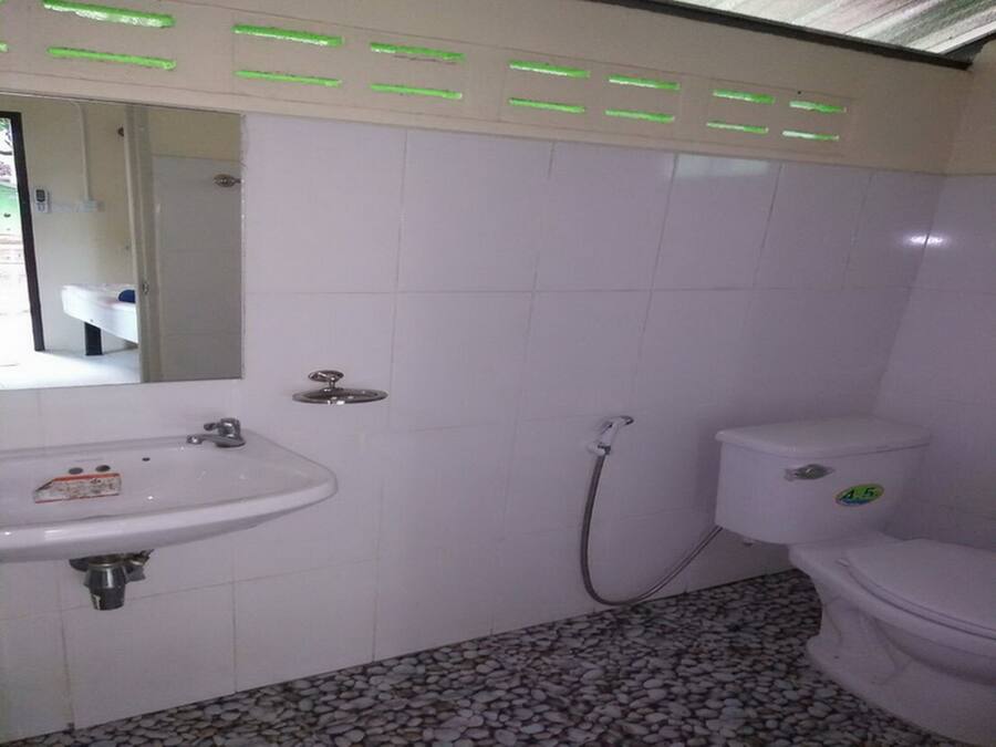 A bathroom with a white sink, toilet, and shower.
