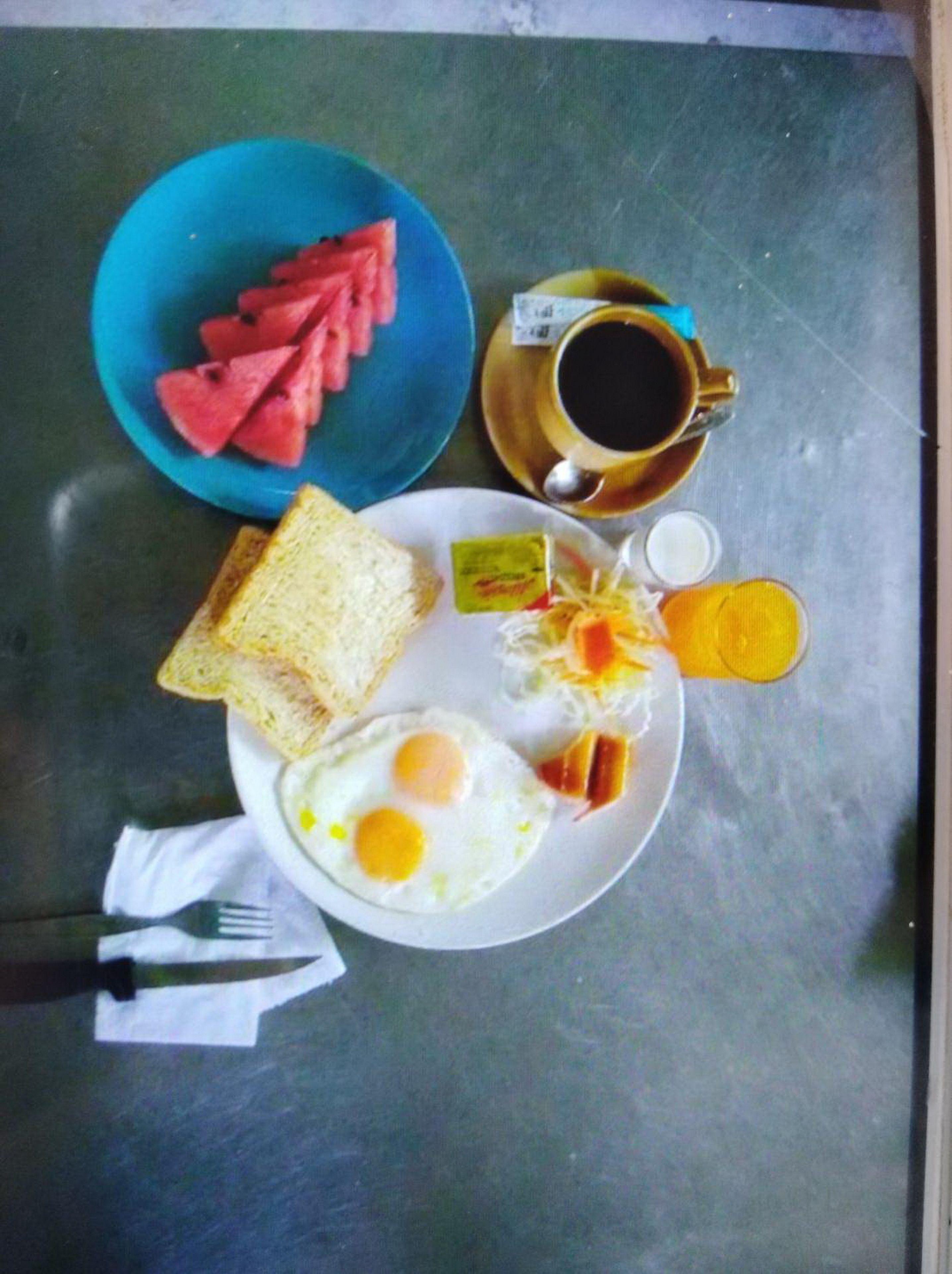 Un plato de desayuno con tostadas, huevos y una taza de café.