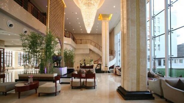 A spacious lobby with a high ceiling, a grand staircase, and a large chandelier. - Huashan Mountain International Hotel (Xi'an)